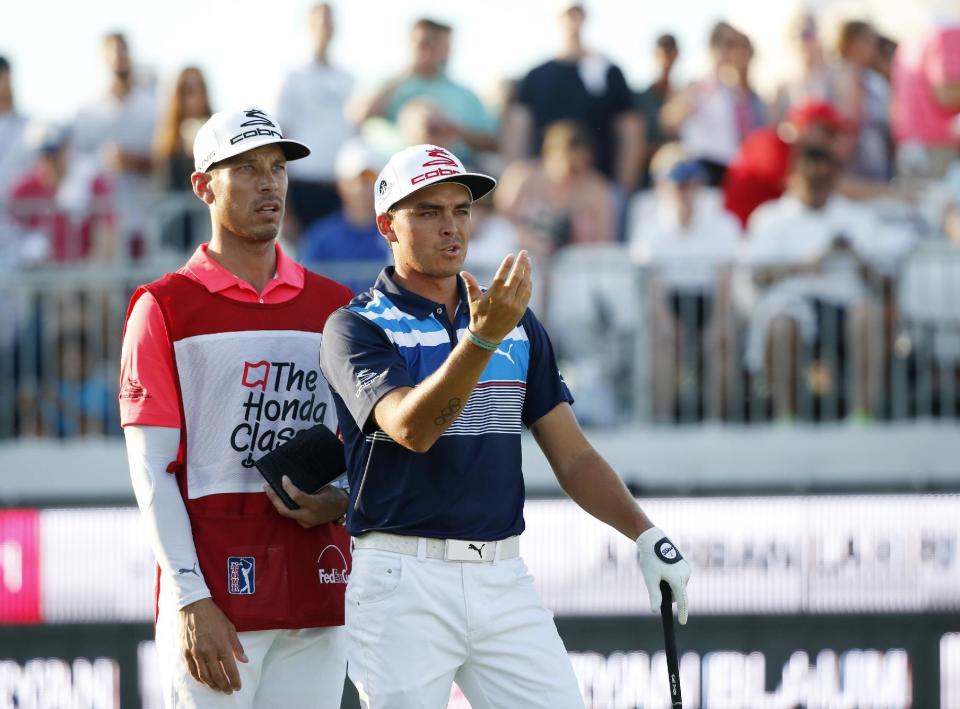 Rickie Fowler, right, talks to his caddie Joe Skovron before hitting on the 16th hole during the third round of the Honda Classic golf tournament, Saturday, Feb. 25, 2017, in Palm Beach Gardens, Fla. (AP Photo/Wilfredo Lee)