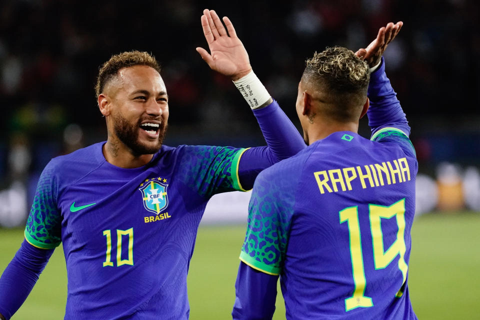 PARIS, FRANCE - SEPTEMBER 27: Neymar of Brazil celebrates with Raphinha of Brazil  after he scores a penalty to make it 4-1 during the International Friendly between Brazil and Tunisia at Parc des Princes on September 27, 2022 in Paris, France. (Photo by Marc Atkins/Getty Images)