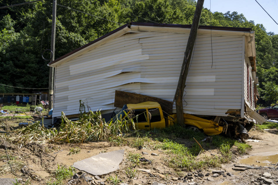 Image: A car remains crushed under a house that floated down River Caney Creek in Breathitt County, Ky. on Aug. 3, 2022. (Michael Swensen for NBC News)