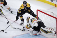 Vegas Golden Knights goaltender Marc-Andre Fleury, right, reaches for the puck against Boston Bruins center Charlie Coyle (13) during the first period of an NHL hockey game in Boston, Tuesday, Jan. 21, 2020. (AP Photo/Charles Krupa)