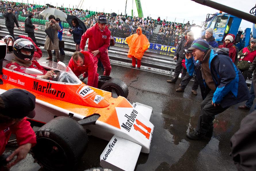 This image released by Universal Pictures shows Chris Hemsworth, left, and director Ron Howard on the set of "Rush." The film, chronicling Formula One's 1976 world championship between Niki Lauda and James Hunt, opens nationwide on Friday, Sept. 27. (AP Photo/Universal Pictures, Jaap Buitendijk)