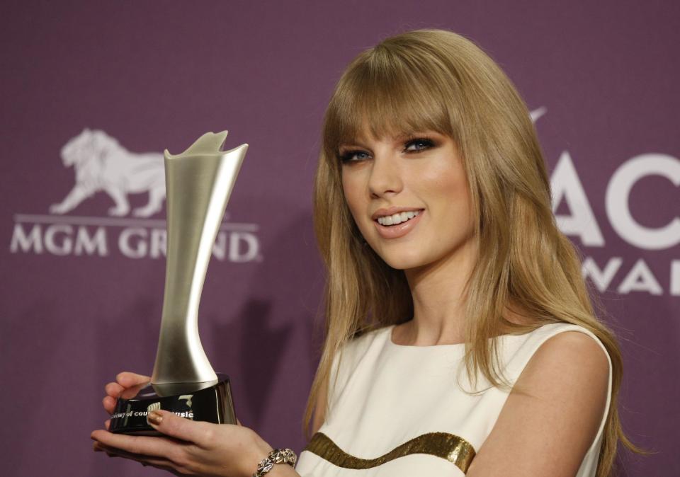 Taylor Swift poses backstage with the award for entertainer of the year at the 47th Annual Academy of Country Music Awards on Sunday, April 1, 2012 in Las Vegas. (AP Photo/Isaac Brekken)