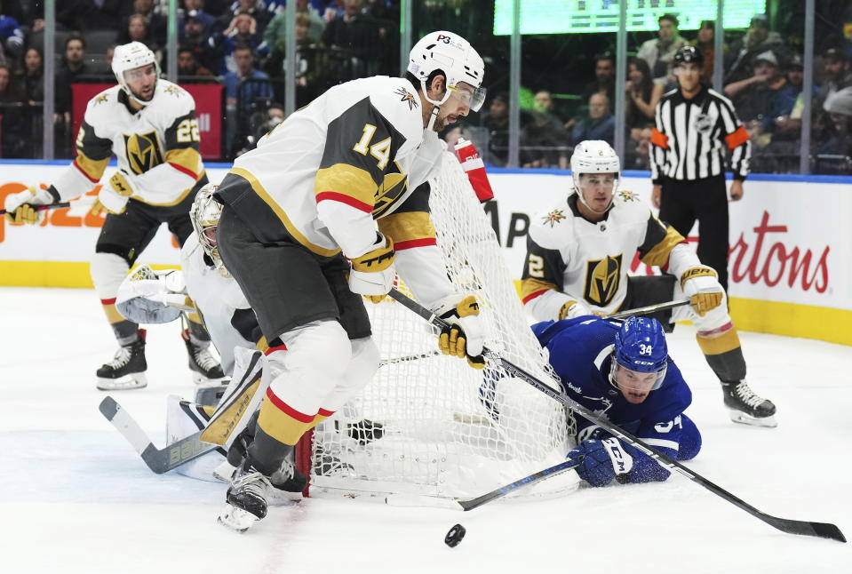 Toronto Maple Leafs forward Auston Matthews (34) tries a wrap around as Vegas Golden Knights defenseman Nicolas Hague (14) and defenseman Zach Whitecloud (2) defend during the second period of an NHL hockey game, Tuesday, Nov. 8, 2022 in Toronto. (Nathan Denette/The Canadian Press via AP)