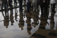 People wait for a meeting with the Military junta led by Col. Mamady Doumbouya, at the people's palace in Conakry, Guinea Wednesday, Sept. 15, 2021. Guinea's junta is expected to face more pressure to set a timeframe for new elections Tuesday as the military rulers open a four-day series of meetings about the West African nation's future following the president's overthrow in a coup just over a week ago. (AP Photo/Sunday Alamba)