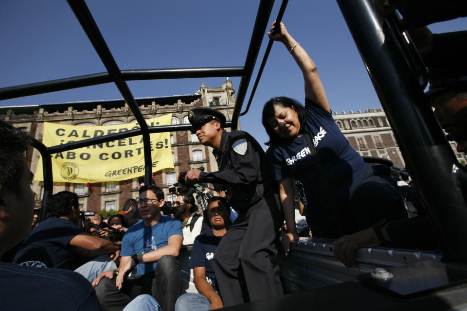 The police detain Greenpeace activists who were hanging a banner from a building in front of the Zocalo, Mexico City's main plaza,Tuesday March 27, 2012. Greenpeace is protesting plans to build a resort in Cabo Pulmo on the Baja California peninsula. The banner reads in Spanish; "Calderon: Cancel Cabo Cortes," the commercial name of the planned resort. (AP Photo/Marco Ugarte)