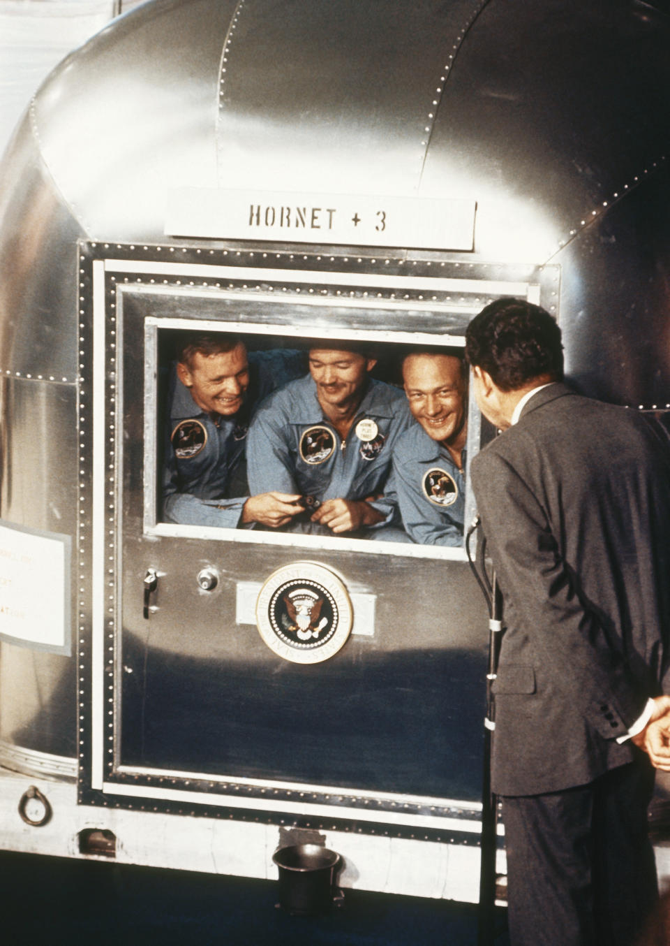 FILE – In this July 24, 1969 file photo, President Richard Nixon, right, greets the Apollo 11 astronauts in the quarantine van on board the U.S.S. Hornet after splashdown and recovery. The Apollo 11 crew from left are Neil Armstrong, Michael Collins, and Edwin “Buzz” Aldrin. (AP Photo, File)