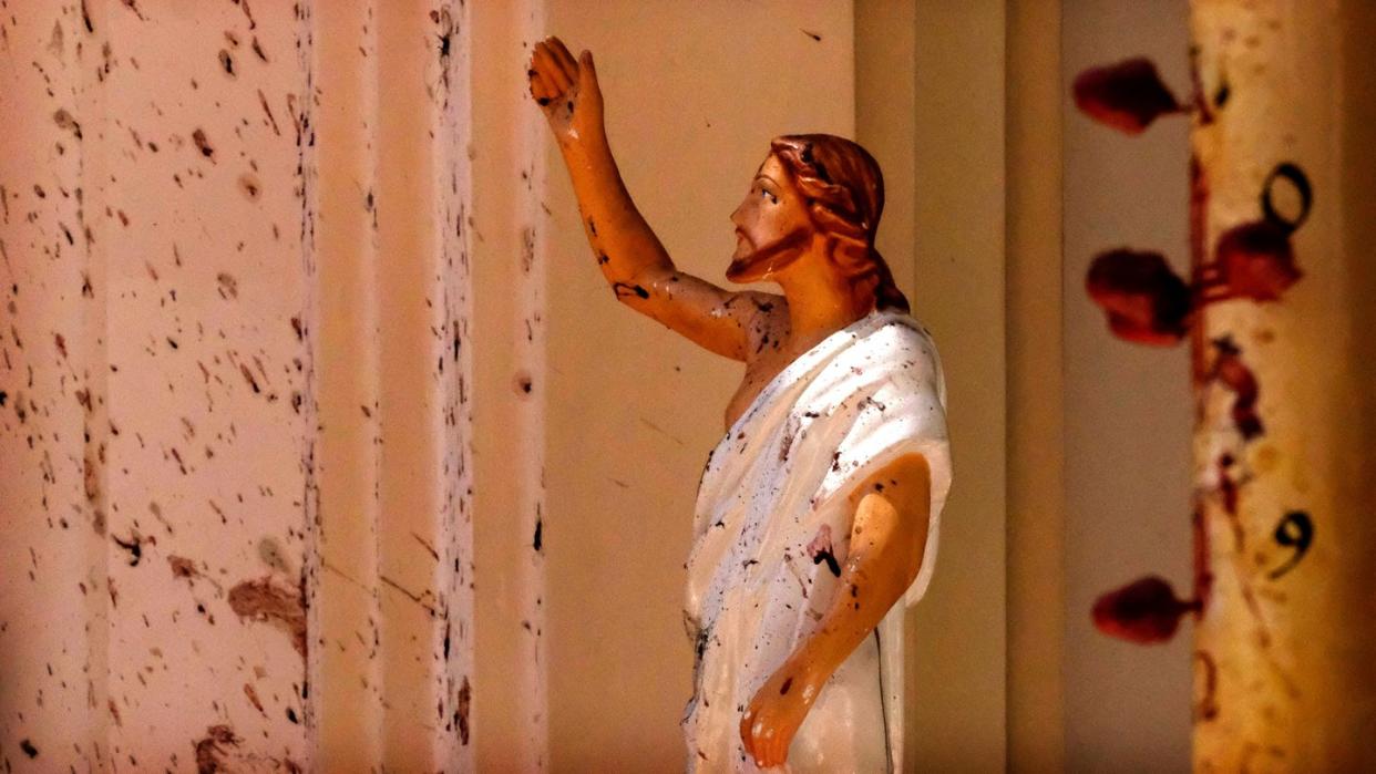 Eine mit Blutflecken beschmierte Jesus-Figur in der St.-Sebastians-Kirche. Foto: AP