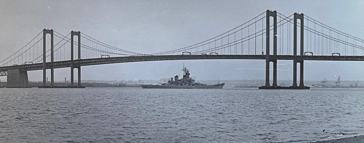 The Battleship Winconsin goes under the Delaware Memorial Bridge on her way to the Philadelphia Navy Yard in this photo taken on June 13, 1989.