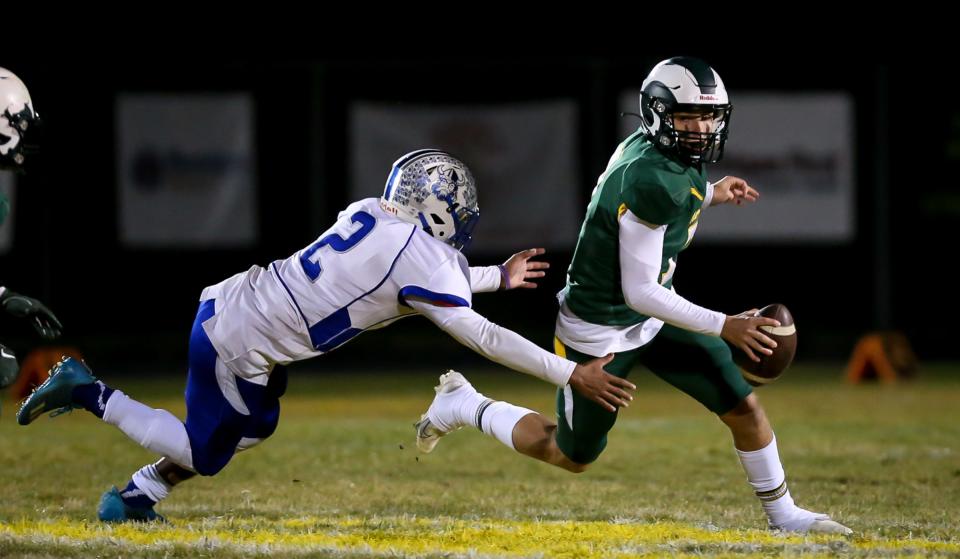 Flat Rock's Graham Junge (right) evades a tackle by Dundee's Trey Parker in the first quarter Friday, Oct. 28, 2022.