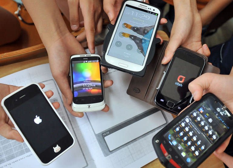 Children display their smartphones after a special class on smartphone addiction, at an elementary school in Seongnam, south of Seoul, on June 11, 2013. South Korea, after boasting for years advanced technology from high-speed Internet to Samsung smartphones, is now taking pains to try to pull its tech-crazed youth away from digital addiction