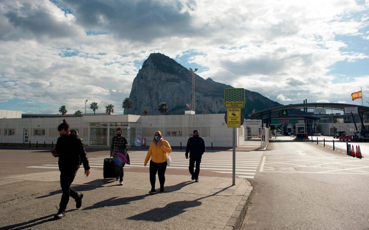 People cross the border between Spain and Gibraltar in La Linea de la Concepcion on January 4, 2021. - Gibraltarians have reacted with relief and caution after Madrid and London reached a deal allowing the territory to become part of Europe's passport-free zone to keep movement fluid on its border with Spain. - Jorge Guerrero/AFP