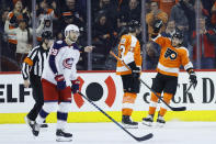 Philadelphia Flyers' Kevin Hayes (13) and Ivan Provorov (9) celebrate past Columbus Blue Jackets' Oliver Bjorkstrand (28) after a goal by Hayes during the first period of an NHL hockey game, Tuesday, Feb. 18, 2020, in Philadelphia. (AP Photo/Matt Slocum)
