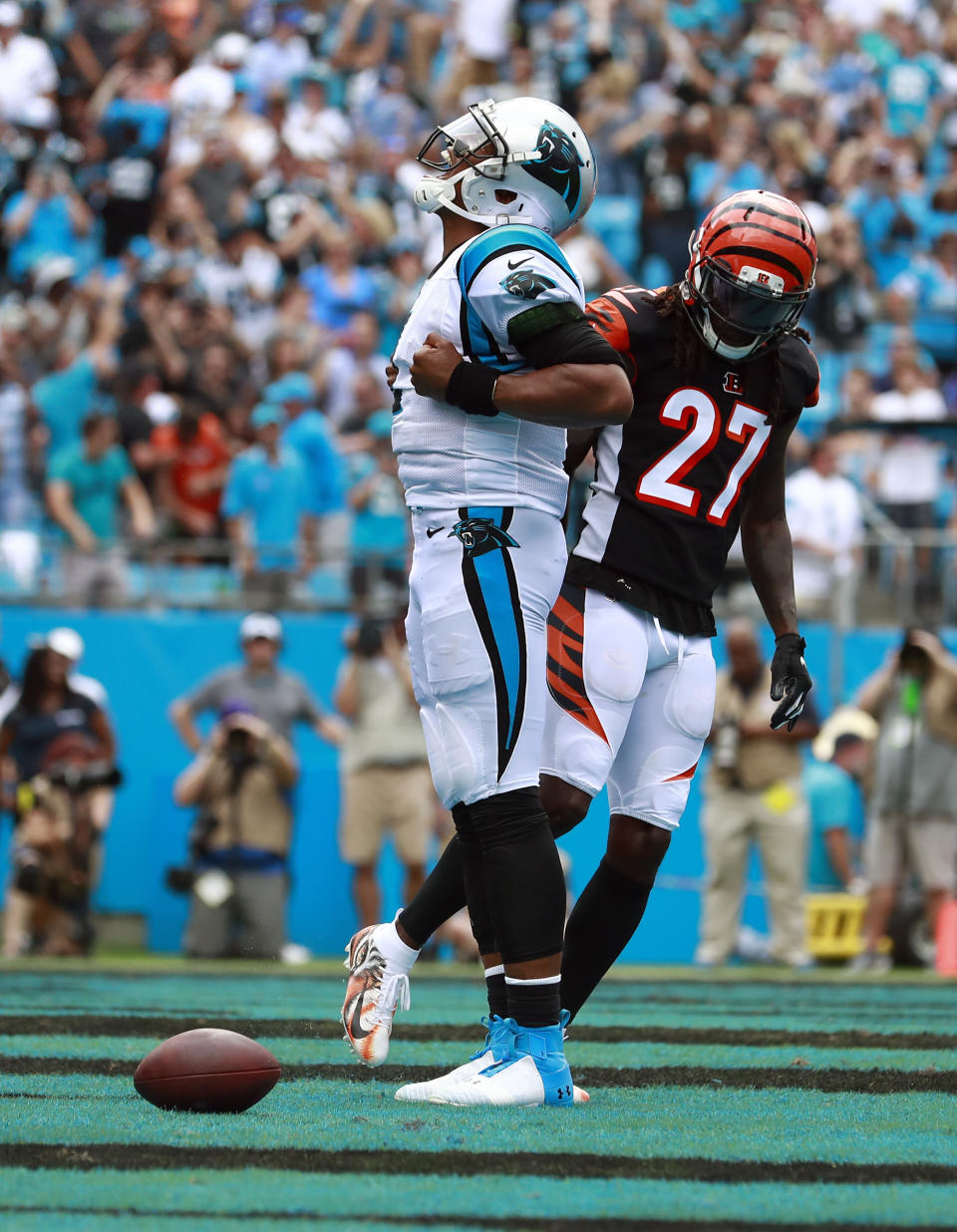 Cincinnati Bengals' Dre Kirkpatrick (27) kicks the football as Carolina Panthers' Cam Newton (1) celebrates his touchdown run during the second half of an NFL football game in Charlotte, N.C., Sunday, Sept. 23, 2018. (AP Photo/Jason E. Miczek)