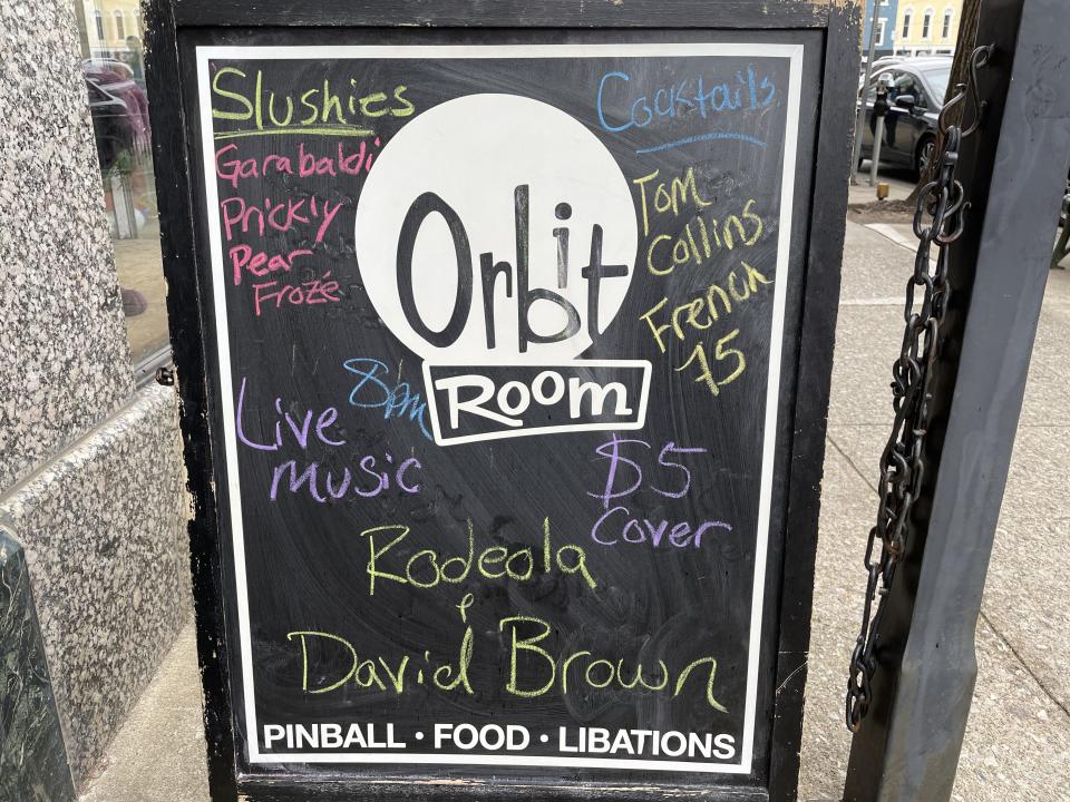 A sign outside the Orbit Room promotes slushies, cocktails, food, pinball and live music.