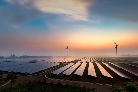 A solar and wind farm at sunrise.