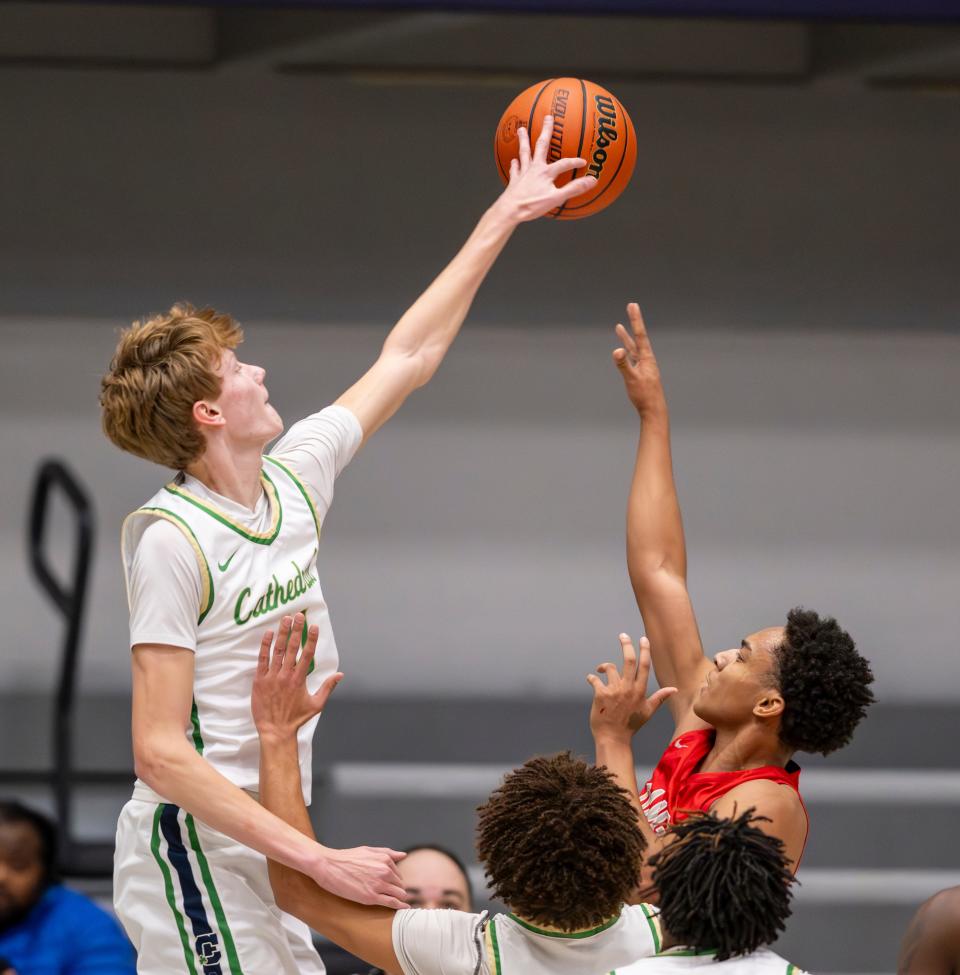 Indianapolis Cathedral High School junior Brady Koehler (11) blocks a shot by Evansville Bosse High School junior Tizaun Tomlinson (1) during the first half of a varsity game in the SNKRS4SANTA Shootout, Saturday, Dec. 2, 2023, at Brownsburg High School.