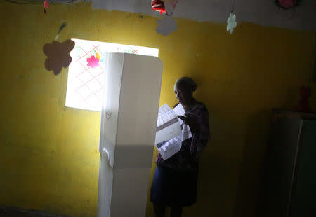 A woman reads ballot papers at a polling station as Haiti holds a long-delayed presidential election after a devastating hurricane and more than a year of political instability, in Port-au-Prince, Haiti, November 20, 2016. REUTERS/Jeanty Junior Augustin