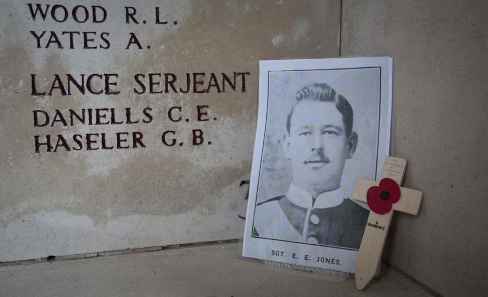 In this photo taken on Nov. 12, 2013, a photo of World War One British soldier Sergeant Ernest Edward Jones from Sandwich, Kent, England, is remembered with a wooden cross and message at the Menin Gate in Ypres, Belgium. Britain's Imperial War Museum is launching an ambitious online database on Monday, May 12, 2014 to remember the lives of the millions of men and women who served in World War One. The museum hopes that the history project, timed to coincide with the 100th anniversary of WWI, could form a permanent digital memorial to the scores of soldiers, nurses and others from Britain and the Commonwealth who contributed to the war by piecing together their life stories. (AP Photo/Virginia Mayo)