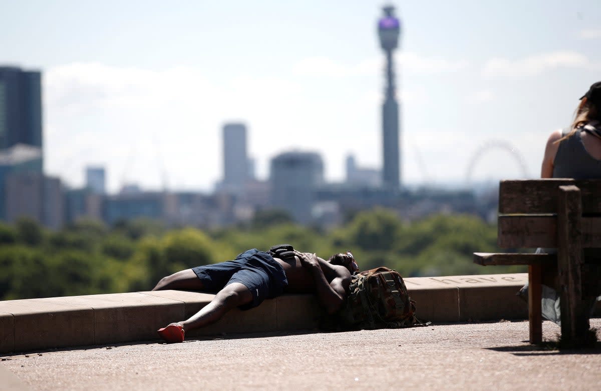 A man lies in the sun at Primrose Hill (REUTERS)