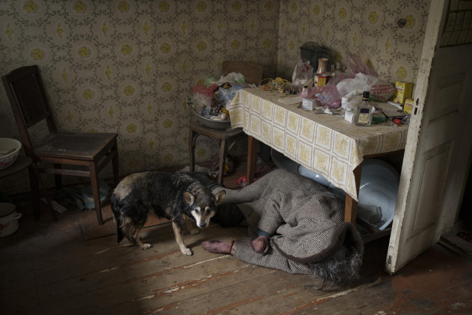 ARCHIVO - Esta fotografía del martes 5 de abril de 2022 muestra a un perro junto al cuerpo de una anciana que fue asesinada dentro de una vivienda en Bucha, Ucrania. (AP Foto/Felipe Dana, archivo)