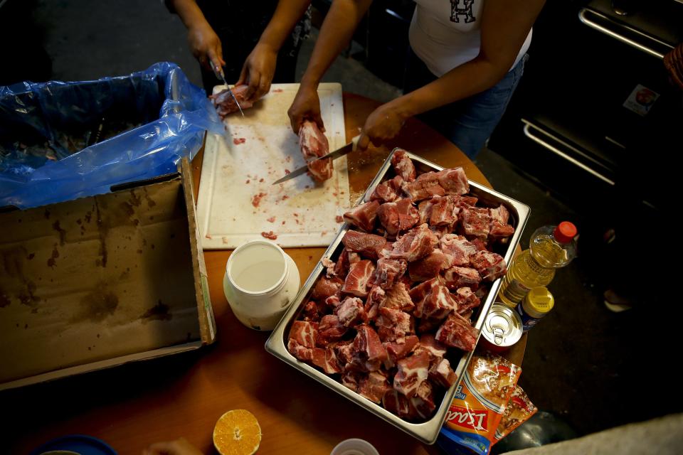 Migrants cooks at the Agape World Mission shelter used mostly by Mexican and Central American migrants who are applying for asylum in the U.S., on the border in Tijuana, Mexico, Monday, June 10, 2019. The mechanism that allows the U.S. to send migrants seeking asylum back to Mexico to await resolution of their process has been running in Tijuana since January. (AP Photo/Eduardo Verdugo)