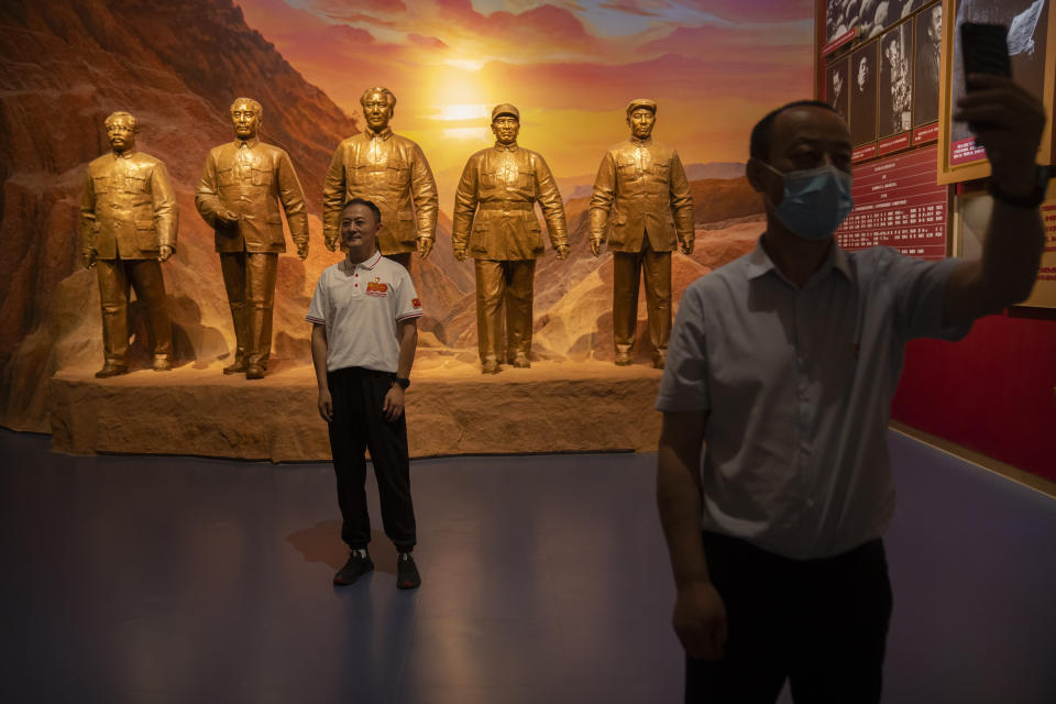 Visitors pose for photos in front of statues of Chinese Leader Mao Zedong, center, and other Communist Party figures at the newly-completed Museum of the Communist Party of China in Beijing, Friday, June 25, 2021. In the build-up to the July 1 anniversary, Xi and the party have exhorted its members and the nation to remember the early days of struggle in the inland hills of Yan'an, where Mao Zedong emerged as party leader in the 1930s. (AP Photo/Mark Schiefelbein)