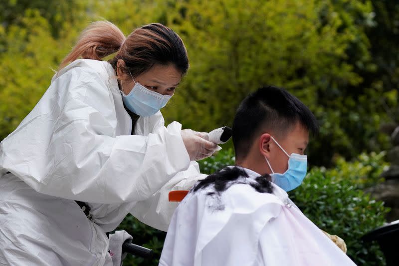 Barber Xiong Juan cuts a customer's hair at a residential compound in Wuhan