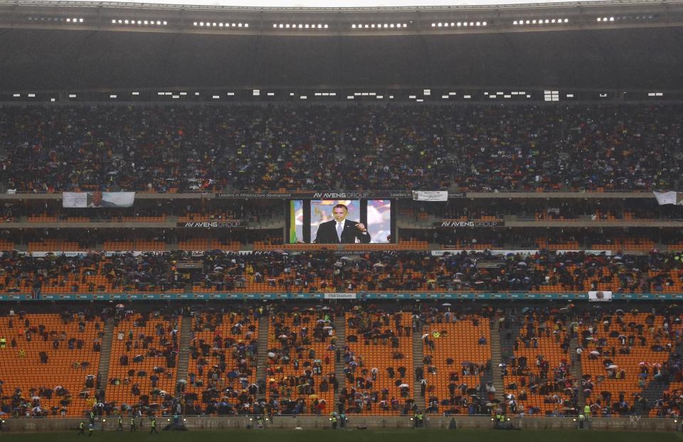 An image of President Barrack Obama is flashed on a screen as he makes his speech during the memorial service for former South African president Nelson Mandela at the FNB Stadium in Soweto, near Johannesburg, South Africa, Tuesday Dec. 10, 2013. (AP Photo/Markus Schreiber)