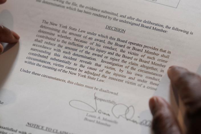 In this April 19, 2023 photo, Debra Long of Poughkeepsie, N.Y., holds the letter that explains why she was initially denied reimbursement for the funeral of her son, Randy Long, who was murdered in 2006. An AP examination of data from 23 states shows that Black people are disproportionately denied aid from programs that reimburse victims of violent crime. (AP Photo/Seth Wenig)