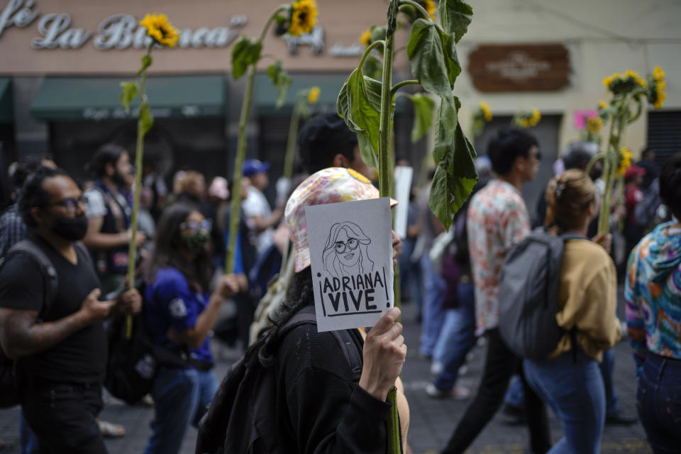 A protestor holds up a sign with a drawing depicting Adriana Hernandez, a student who died when two subway trains collided while between stations on Jan. 7, during a march asking for security in the city's subway system, in Mexico City, Friday, Jan. 20, 2023. More than 6,000 National Guard officers are posted in the city's subway system after a series of accidents that officials suggested could be due to sabotage. (AP Photo/Eduardo Verdugo)