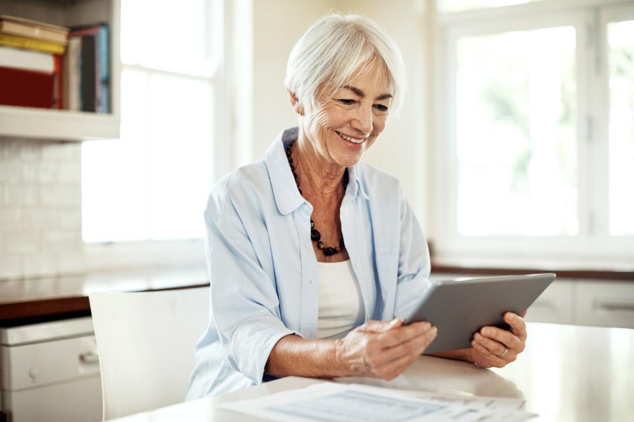 senior looking at tablet smiling