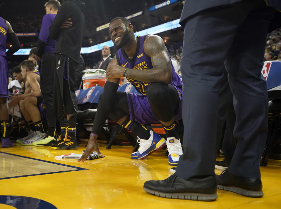 LeBron James was in pain on the bench Tuesday night against the Warriors. (AP)