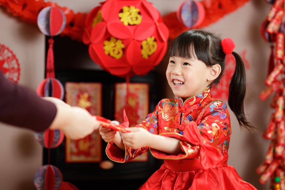 Los padres les dan sobres rojos con dinero a sus hijos para desearles buena suerte y salud. <a href="https://www.shutterstock.com/es/image-photo/chinese-young-girl-traditional-dressing-fumeans-1892445205" rel="nofollow noopener" target="_blank" data-ylk="slk:Maples Images/Shutterstock;elm:context_link;itc:0;sec:content-canvas" class="link ">Maples Images/Shutterstock</a>