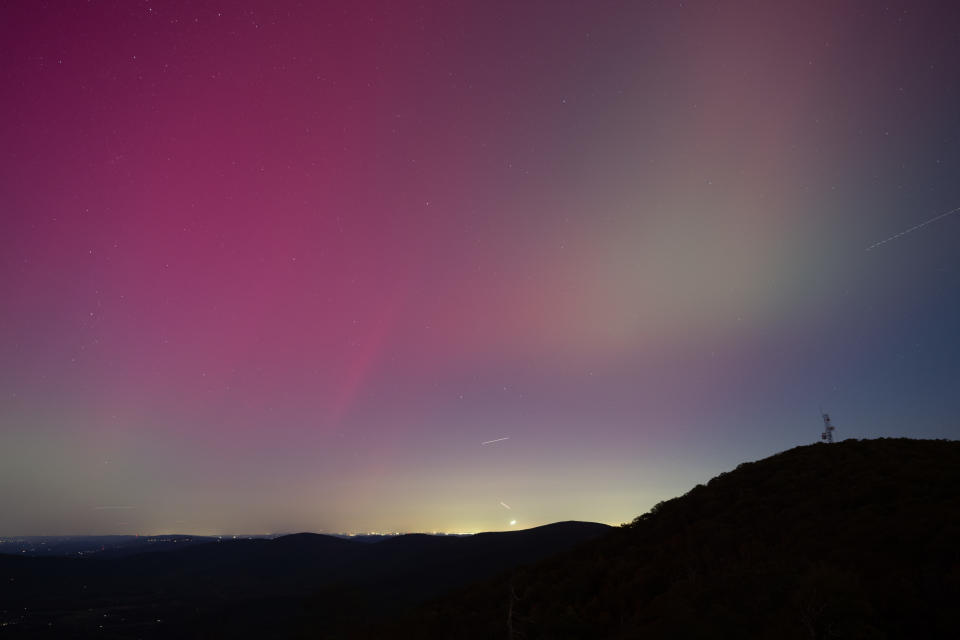 A beautiful night sky with visible auroras over a silhouetted mountain landscape. No people or text are present