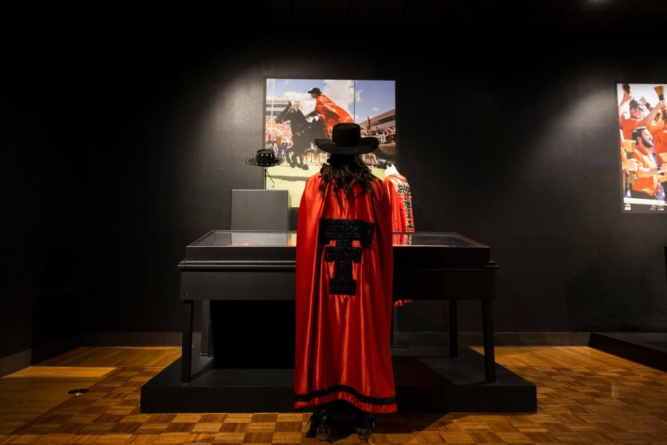 The Masked Rider standing in front of the Masked Rider display in the Diamond M Gallery in the Museum of Texas Tech. The display is part of the Texas Tech Centennial Exhibits the museum has for the centennial celebrations for the institution.