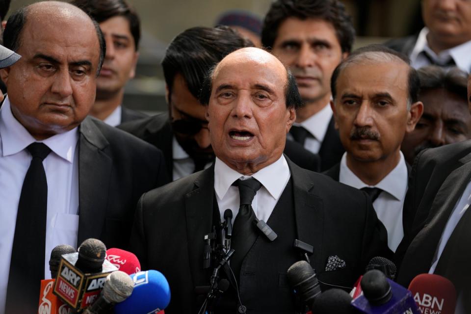 Latif Khosa, centre, a lawyer who is part of Imran Khan’s legal team, speaks with the media outside a court after Khan’s appeal hearing on Wednesday 9 August (AP)