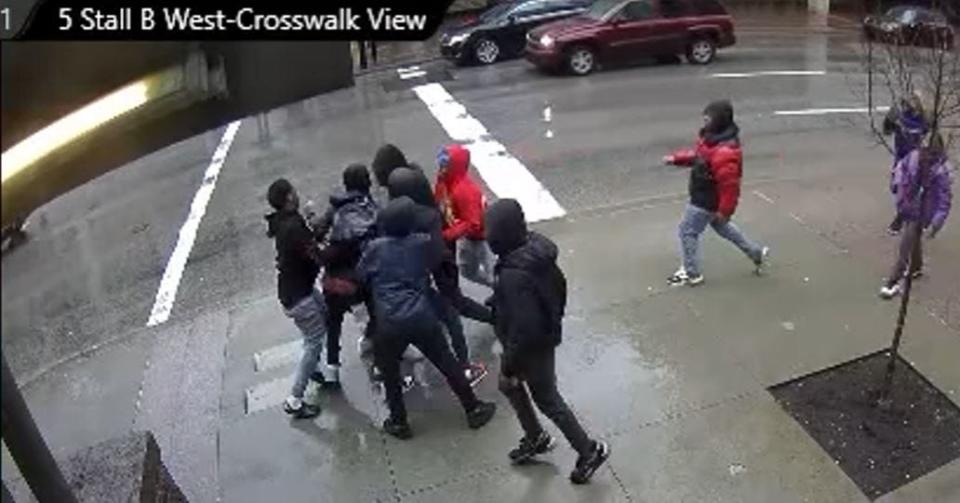 Surveillance video captured a group of teens attacking a pedestrian on East Fifth Street on Jan. 24.