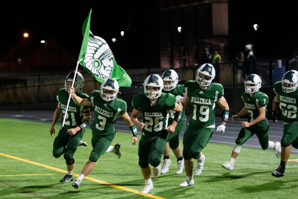 Led by flag-carrying senior captain Dominic Gird and the other captains, the Billerica Indians take the field against Hanover, before the start of the Division 3 round of 8 game in Billerica, Nov. 12, 2021. The Indians defeated the Hawks, 15-14.