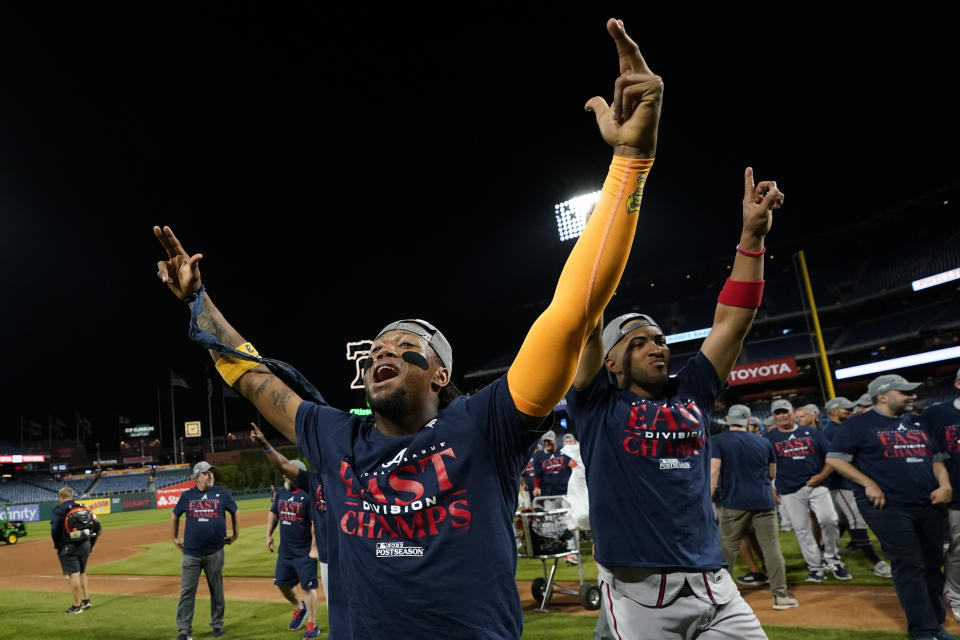 Atlanta Braves' Ronald Acuna Jr., left, and Eddie Rosario celebrate after clinching their sixth consecutive NL East title by defeating the Philadelphia Phillies in a baseball game, Wednesday, Sept. 13, 2023, in Philadelphia. (AP Photo/Matt Slocum)