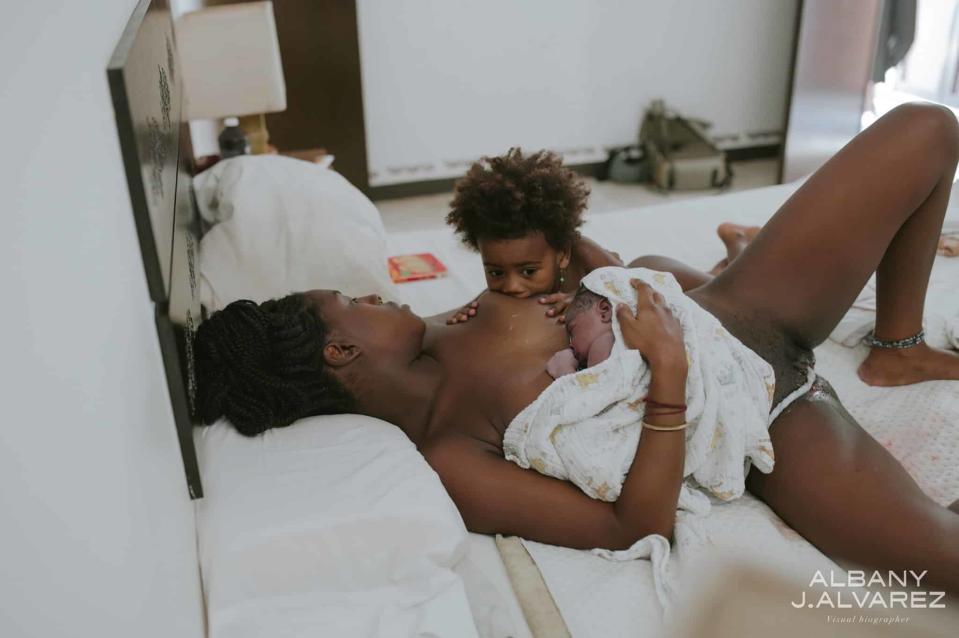 A mother and child sharing a moment on the bed, child held in arms, both looking at each other