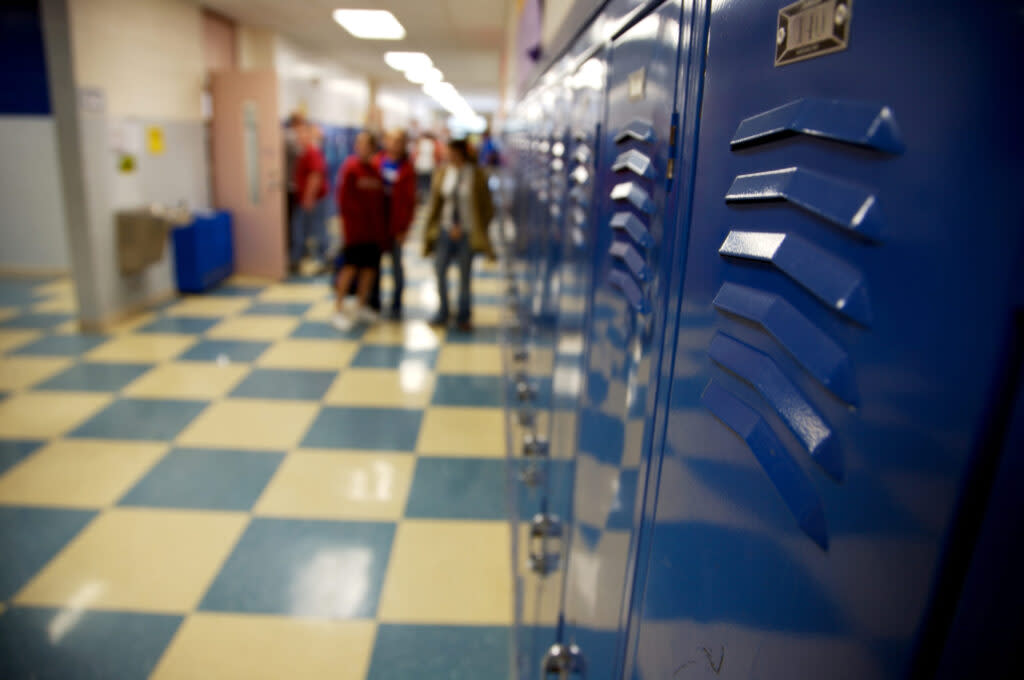 students circulate in a school corridor next to lockers