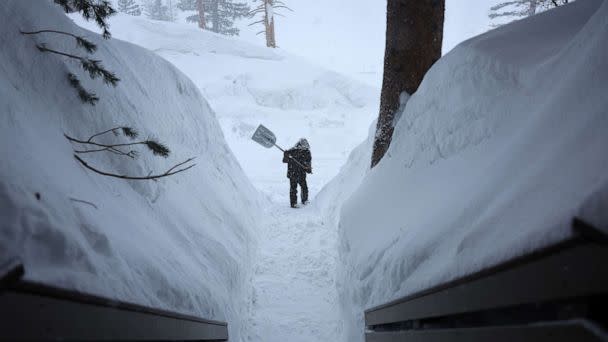 PHOTO: A worker shovels a walkway as snow falls in the Sierra Nevada mountains from yet another storm system which is bringing heavy snow to higher elevations on March 28, 2023 in Mammoth Lakes, Calif. (Mario Tama/Getty Images)