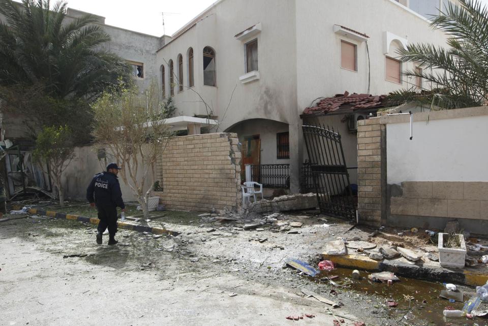 A security personnel stands near the site of a bomb blast at the gate of the Iranian ambassador's residence in Tripoli