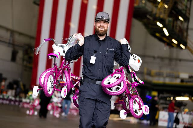 <p>Casey Sykes for Rank Studios/Delta Air Lines</p> A Delta team member carries bikes at A Toys for Tots event at Delta Tech Ops in Atlanta, Ga. In 2022, Delta contributed $50.5 million in charitable giving to community partners including Habitat for Humanity, Junior Achievement, KABOOM!, Covenant House, YMCA, BCRF, Marine Toys for Tots, USO and many more.