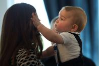 <p>Prince George, 9 months, plays with his mother Kate Middleton's hair during an official visit to Government House in Wellington, New Zealand.</p>