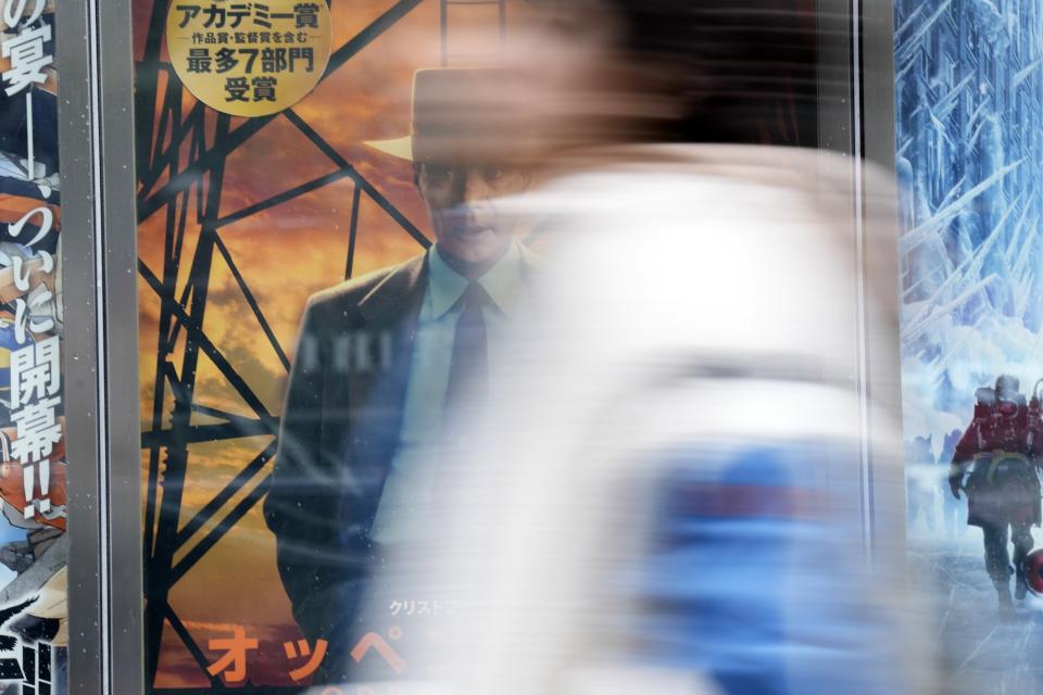 A person stands in front of the advertisements of films on showing at a movie theater including the seven Academy Award winning movie "Oppenheimer" Friday, March 29, 2024, in Tokyo. “Oppenheimer” finally premiered Friday in the nation where two cities were obliterated 79 years ago by the nuclear weapons invented by the American scientist who was the subject of the Oscar-winning film. Japanese filmgoers' reactions understandably were mixed and highly emotional. (AP Photo/Eugene Hoshiko)