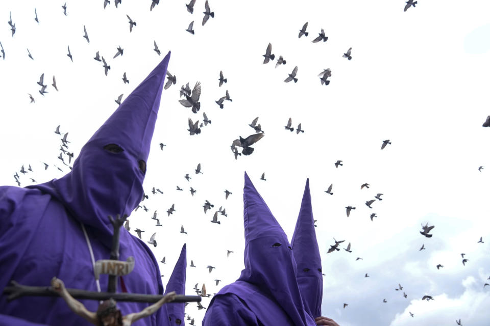 Pájaros sobrevuelan a penitentes, conocidos popularmente como cucuruchos, durante la procesión de Jesús del Gran Poder del Viernes Santo, dentro de la celebración de la Semana Santa, en Quito, Ecuador, el 29 de marzo de 2024. (AP Foto/Dolores Ochoa)