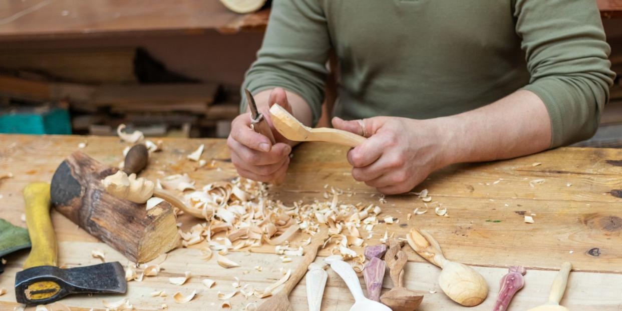 spoon master in his workshop with wooden products and tools