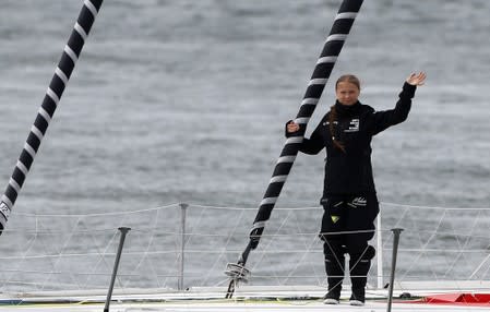 Swedish teenage climate activist Greta Thunberg waves from a yacht as she starts her trans-Atlantic boat trip to New York, in Plymouth