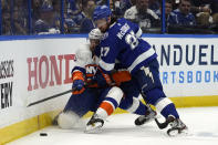 Tampa Bay Lightning defenseman Ryan McDonagh (27) drives New York Islanders center Mathew Barzal (13) into the dasher during the third period in Game 1 of an NHL hockey Stanley Cup semifinal playoff series Sunday, June 13, 2021, in Tampa, Fla. (AP Photo/Chris O'Meara)